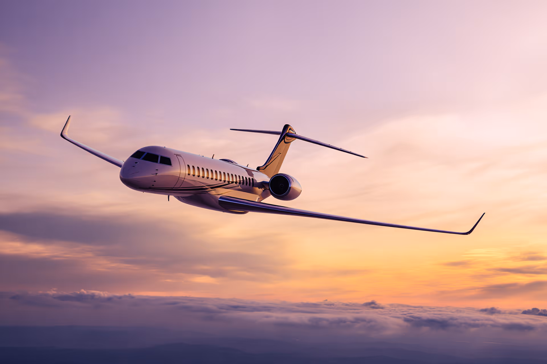 Private jet flying above clouds during a purple and orange sunset.