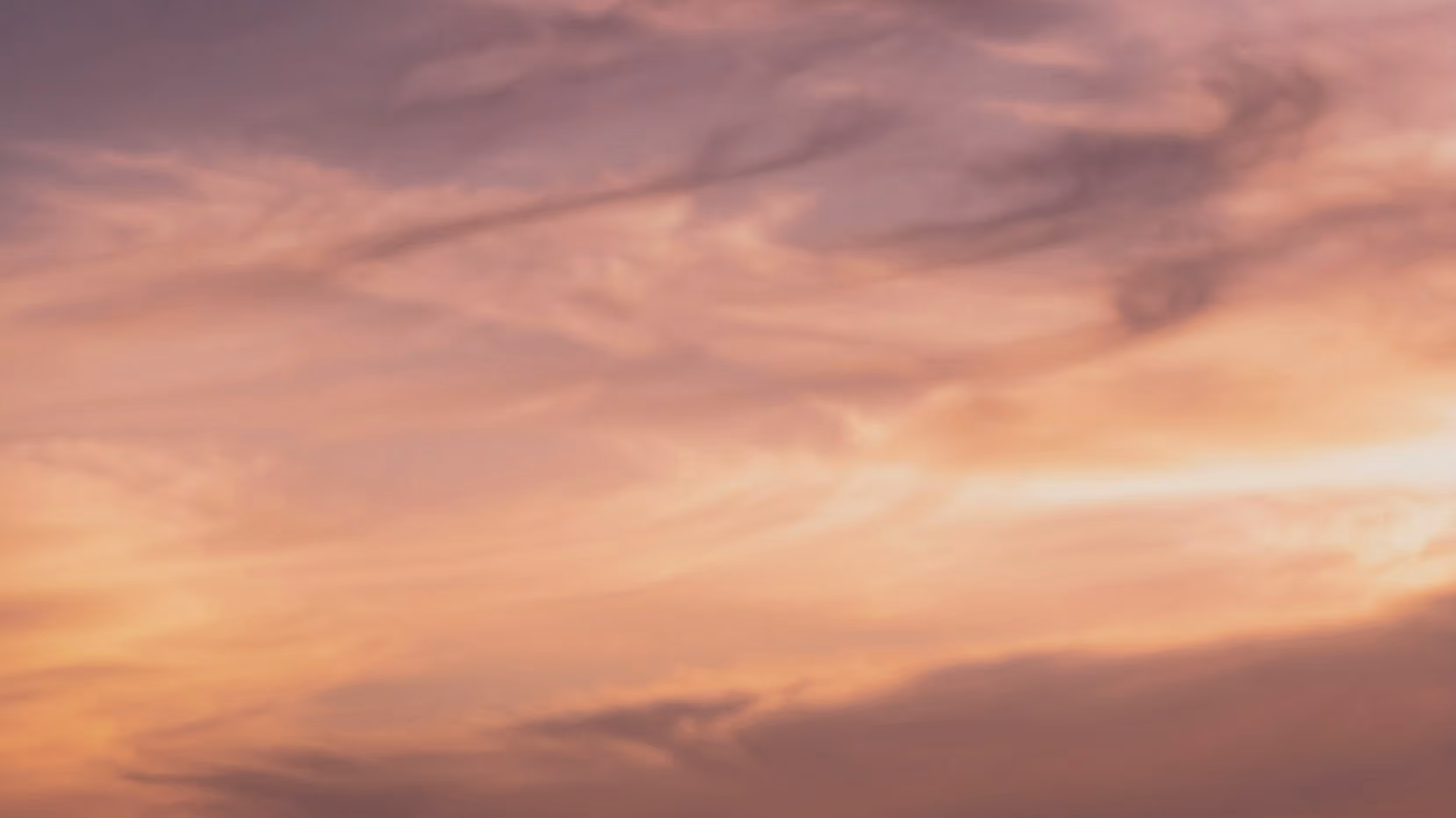 Softly colored sky at sunset with shades of pink, purple, and orange clouds.